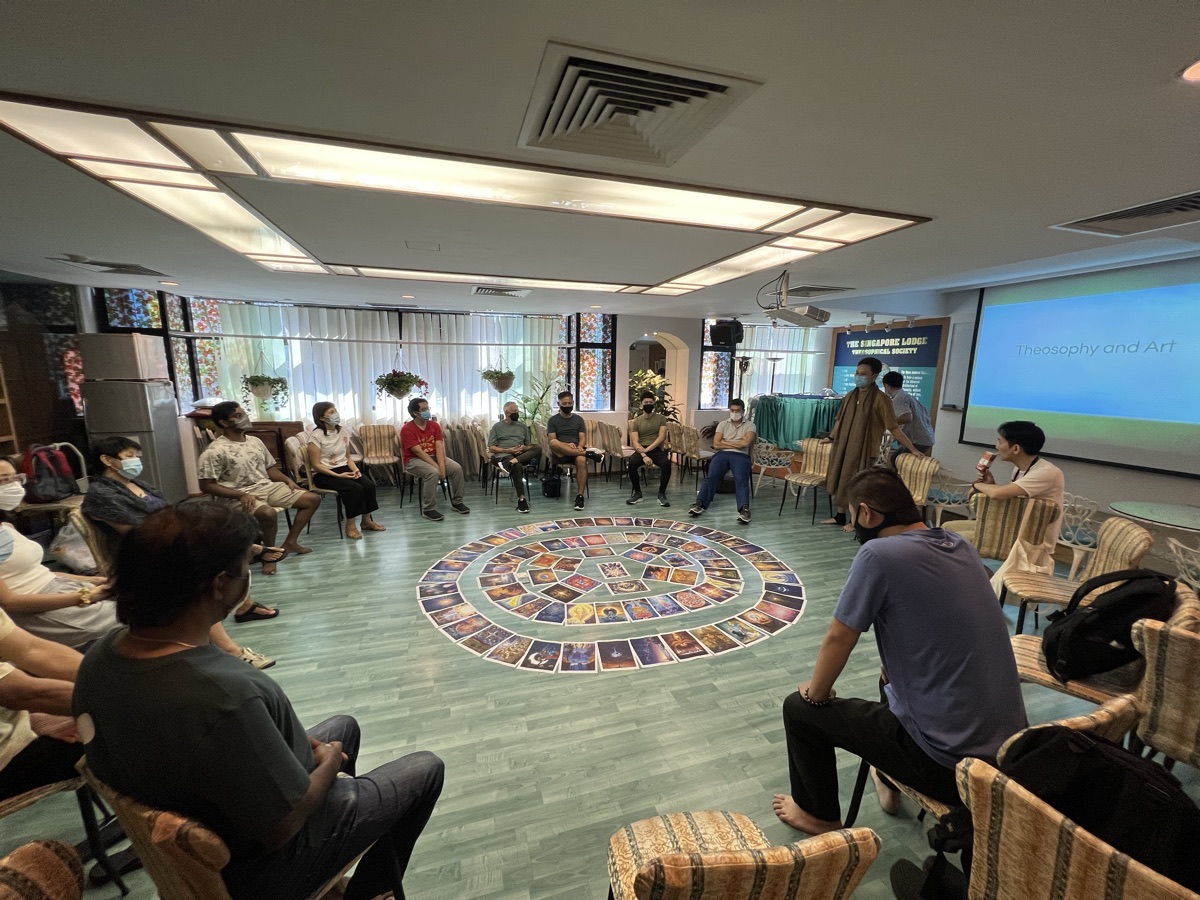 Workshop participants seated around a circular arrangement of cards