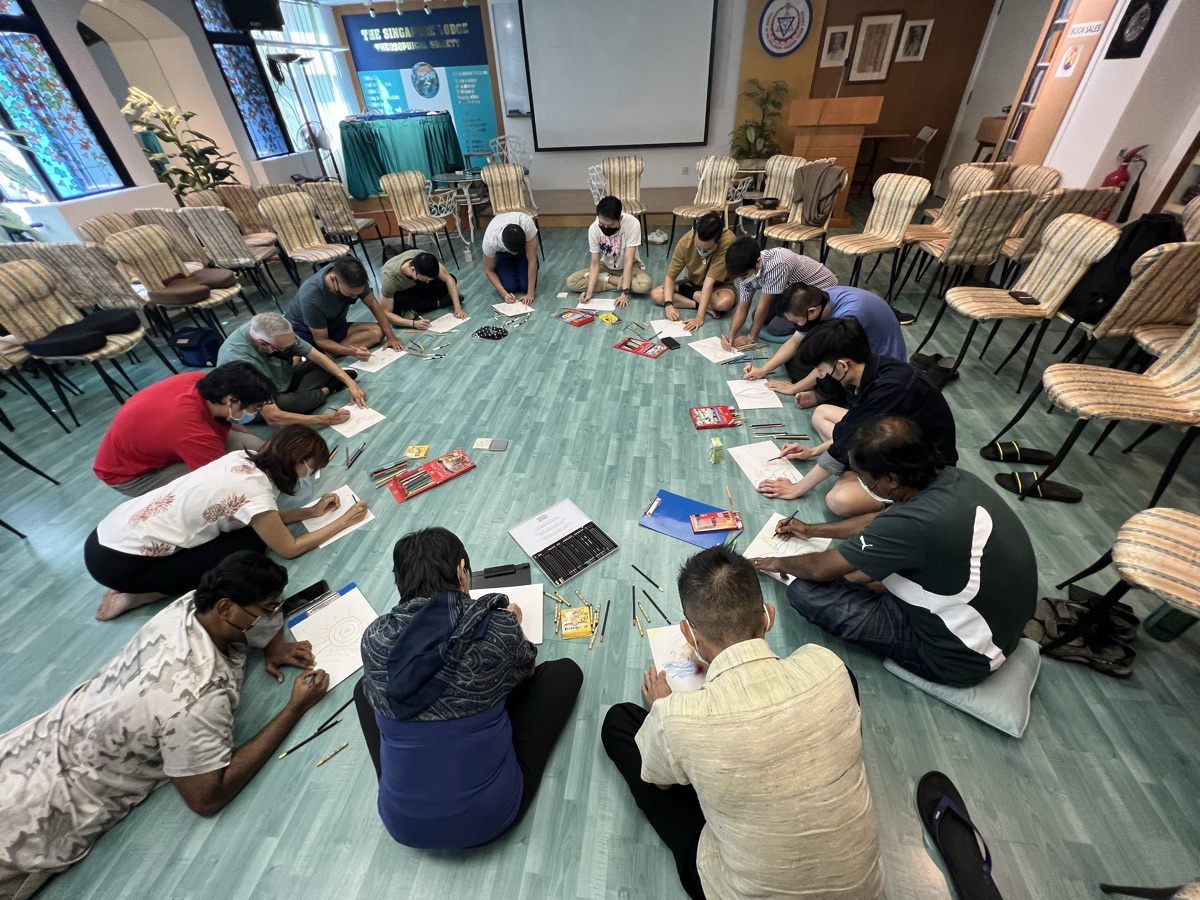 Participants writing while seated in a circle