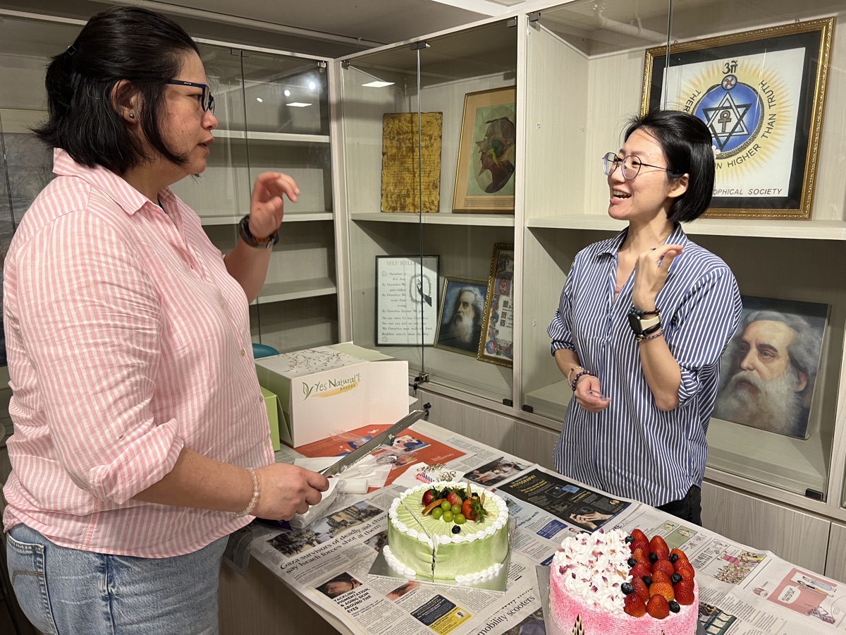 Two people talking beside celebration cakes